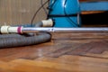 Blue vacuum cleaner stands on old parquet floor