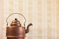 Antique vintage copper kettle on the background of old wallpaper Royalty Free Stock Photo