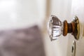 An antique vintage glass doorknob to a narrow bathroom in a small cottage house Royalty Free Stock Photo