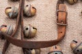 Antique vintage leather strap with oxidize brass buckle from sleigh bells on burlap Royalty Free Stock Photo