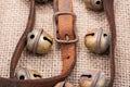 Antique vintage leather strap with oxidize brass buckle from sleigh bells on burlap Royalty Free Stock Photo