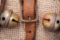 Antique vintage leather strap with oxidize brass buckle from sleigh bells on burlap Royalty Free Stock Photo