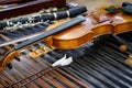 Antique violin and violin bow lying on dulcimer. Close up a violin instrument and cymbal before a concert