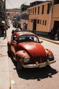 Antique Volkswagen Beetle is parked on the side of a quiet road. Royalty Free Stock Photo
