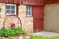 Antique Wagon Wheel Leaning on Old Stone Barn Wall Royalty Free Stock Photo