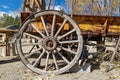 An antique wagon wheel with wooden spokes on a rusty wagon Royalty Free Stock Photo