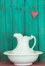 Antique water pitcher and basin by rustic teal blue wooden background Royalty Free Stock Photo