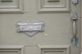 Antique weather worn door handle and mail slot.