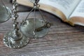 Antique weighing balance scale, an old key, and an open Holy Bible Book with golden pages on a wooden table Royalty Free Stock Photo