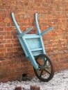 Antique Wheel Barrow Against Brick