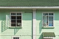 Antique white frame wooden window with light and shadow on the old green pastel brick wall exterior office building or home and Royalty Free Stock Photo