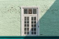 Antique white frame wooden window with light and shadow on the old green pastel brick wall exterior office building or home and Royalty Free Stock Photo