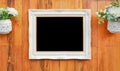 Antique white photo frame with black empty space for your picture or text placed on wood plank wall background Royalty Free Stock Photo