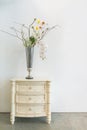 Antique white wooden cabinet and standing lamp light bulb with beautiful flower in vase glass on white wall interior for home and Royalty Free Stock Photo