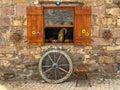 Antique window detail and wheel, chair and wheel in front of antique building facade Royalty Free Stock Photo