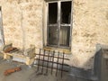 Antique window with rusty grate and masonry bench Royalty Free Stock Photo