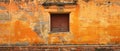 An antique window is set in a crumbling orange wall, entwined with ivy, standing as a relic of a bygone era. Its