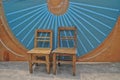 Antique wooden basic chairs and blue Chinese fan wall background Royalty Free Stock Photo