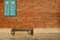 Antique wooden chair against a grungy brick wall with wooden blue window Royalty Free Stock Photo