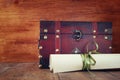 Antique wooden chest with old parchment on wooden table Royalty Free Stock Photo