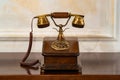 An antique wooden disc phone with a gilded handset on the nightstand Royalty Free Stock Photo