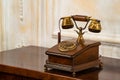 An antique wooden disc phone with a gilded handset on the nightstand Royalty Free Stock Photo