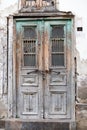 Antique wooden door with carved inserts  patterns of metal rods and glass. Peeling green blue paint and chain and lock. Vertical Royalty Free Stock Photo