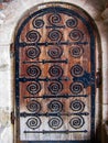 Antique wooden door decorated with wrought iron decorative elements Royalty Free Stock Photo