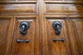 Antique wooden door with hand-shaped knockers