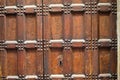 Antique wooden door with metal rivets and keyhole. Close up shot. Aged broun wooden mesh structure. Texture or Royalty Free Stock Photo