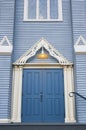 Antique wooden door in to an old wooden church. Blue entrance door. Wooden Gothic Revival style church Royalty Free Stock Photo