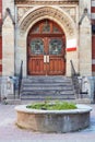 Antique wooden door with windows, carved stone arch and steps of the entrance of a historical building in Montreal, Quebec, Canada