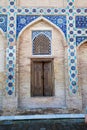 Antique wooden doors in a brick wall decorated with mosaics in the Gur Emir mausoleum in Samarkand, Uzbekistan. 29.04.2019 Royalty Free Stock Photo