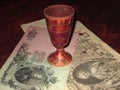 An antique wooden glass on banknotes on the table.