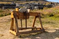 Antique Wooden Grindstone Machine With Rocky Ruins In Background Royalty Free Stock Photo