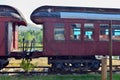 Antique wooden passenger rail cars parked on a train track