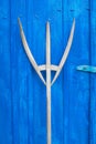 antique wooden pitchfork leaning on blue barn door Royalty Free Stock Photo