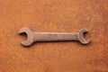 Antique wrench on a rusty background