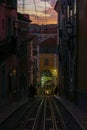 Antique yellow cable car on a narrow Portuguese street at sunset