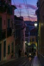 Antique yellow cable car on a narrow Portuguese street at sunset