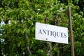 Antiques shop sign hanging on old iron post