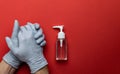 Antiseptic hand using antibacterial sanitizer gel in lab gloves. Clear sanitizer in pump bottle. Medical red background