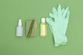 Antiseptic, rubber gloves and aloe vera leaf on green background. Flat lay. Undertone