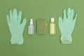 Antiseptic and rubber gloves on green background. Minimal. Undertone