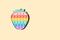 Antistress rainbow strawberry pop-it toy beige background