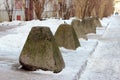 antiterrorist pyramidal concrete pedestals near the house beside the road against the entry of vehicles. Relevant when the danger