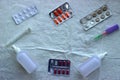 Antiviral and antipyretic capsules, tablets and thermometer on a white disposable diaper. Medical Flatlay