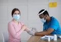 Antiviral protection and immunization. Doctor vaccinating female patient against coronavirus, injecting covid-19 vaccine Royalty Free Stock Photo