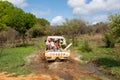 Group of people on the back of a car driving through a muddy forest road. Antsalova, Madagascar Royalty Free Stock Photo