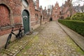 Cycle parked near park and brick houses of historical Beguinage, 13th century complex houses for beguines women